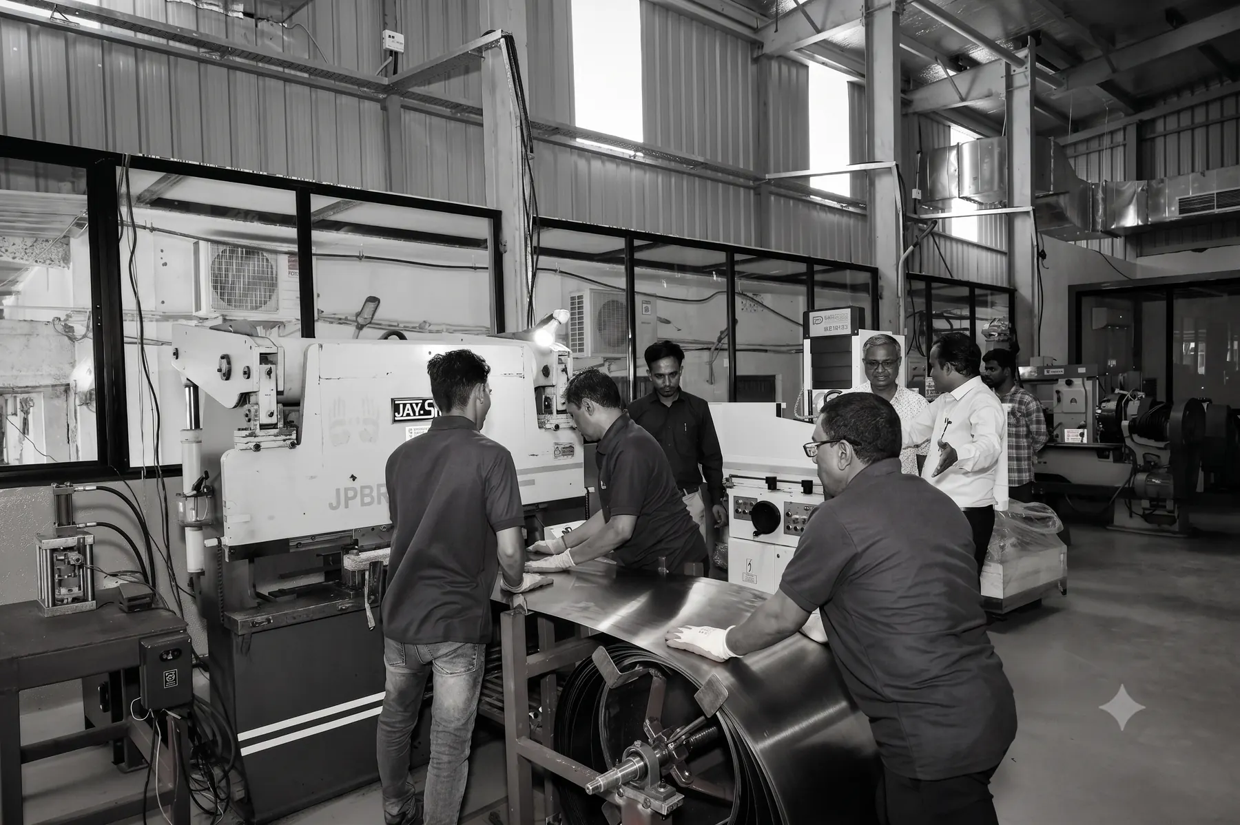 Operators feeding sheet into the press brake at Warora